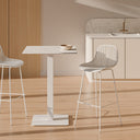 Taburetes CASPER en blanco junto a una mesa alta en una cocina