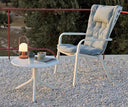 Mesa auxiliar Spritz en blanco con butaca Folio, en una terraza de grava – Nardi