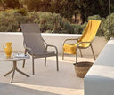 Mesa auxiliar Spritz con sillones Net Lounge en tortora y mostaza, en una terraza – Nardi