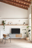 Mueble TV SIERRA de 140 cm con 1 puerta y 3 cajones, en gris, en un salón con vigas de madera – Teulat