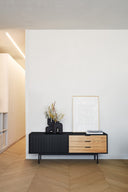 Mueble TV SIERRA de 140 cm con 1 puerta y 3 cajones, en negro, en un salón – Teulat