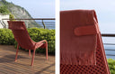 Sillón Net Lounge en coral con toalla, en una terraza con vistas al mar – Nardi