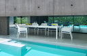 Mesa Rio 210 extensible en blanco con sillas, junto a la piscina, otra vista – Nardi