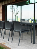 Mesa Rio 210 extensible en antracita con sillas, en una terraza de madera – Nardi