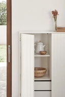 Mueble auxiliar alto SIERRA de 97 cm con 2 puertas y 2 cajones, en blanco, con las puertas abiertas y la vajilla dentro – Teulat