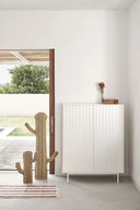 Mueble auxiliar alto SIERRA de 97 cm con 2 puertas y 2 cajones, en blanco, en una habitación con plantas – Teulat