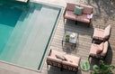 Sillones y sofá KOMODO en antracita con cojines rosa cuarzo junto a la piscina, vista cenital – Nardi