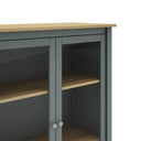 Vitrina MUSGO de 90 cm con 2 puertas de cristal, en verde kaki, en un dormitorio