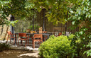 Sillas Trill Armchair en mattone con mesa Tevere LAM en antracita, en un jardín – Nardi