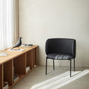 Butaca MOGI de 65 cm en polipiel negro, junto a un mueble bajo – Teulat