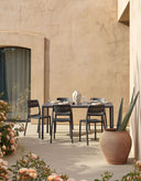 Sillas Cassia Bistrot en antracita con la mesa Piave, en un patio – Nardi