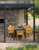 Mesa Rio ALU 210 extensible en antracita con sillas Net en mostaza, bajo una pérgola – Nardi
