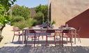 Sillas Cassia en borgoña en una mesa larga de exterior, en un jardín – Nardi