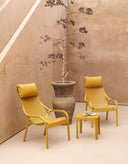 Sillones Net Lounge en mostaza con reposacabezas, en un patio – Nardi