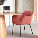 Silla SADIRA con brazos en coral, junto a una mesa redonda – Teulat