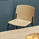 Silla SAGO en roble, junto a una mesa de comedor – Teulat