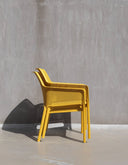 Sillón Net Relax en mostaza junto a una pared de hormigón – Nardi