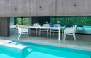 Sillones Net Relax en blanco en una mesa larga junto a la piscina – Nardi
